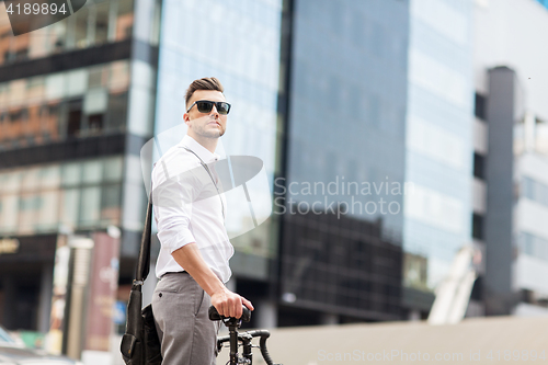 Image of young man with bicycle on city street