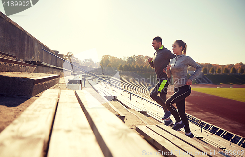 Image of happy couple running upstairs on stadium