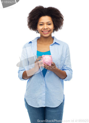 Image of happy afro american young woman with piggy bank