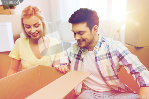 Image of smiling couple with big boxes moving to new home