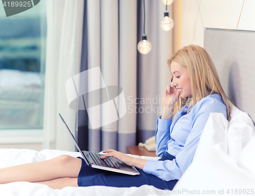 Image of happy businesswoman with smartphone in hotel room