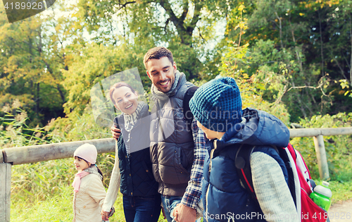 Image of happy family with backpacks hiking in woods