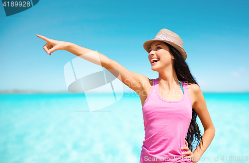 Image of happy young woman in hat on summer beach