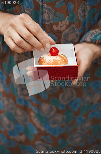 Image of Woman holding eclair in the box