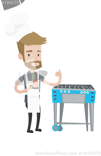 Image of Man cooking meat on gas barbecue grill.