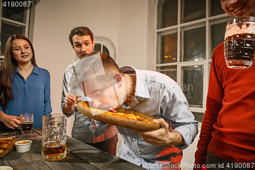 Image of Group of friends enjoying evening drinks with beer