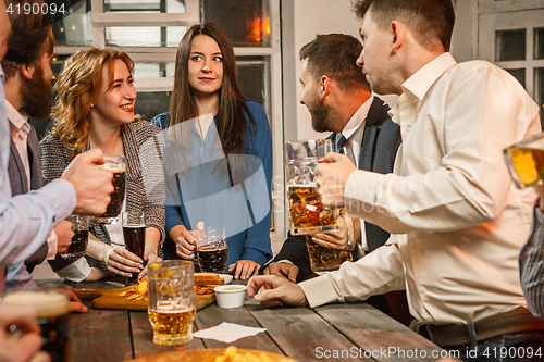 Image of Group of friends enjoying evening drinks with beer