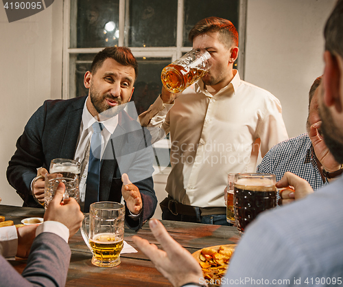 Image of Group of friends enjoying evening drinks with beer