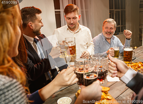 Image of Group of friends enjoying evening drinks with beer