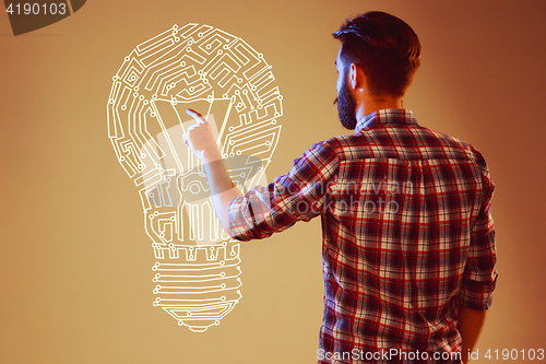 Image of Handsome young man with idea bulb on blue