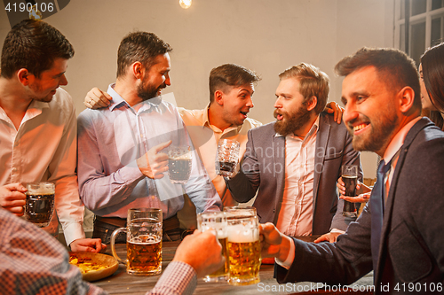 Image of Group of friends enjoying evening drinks with beer