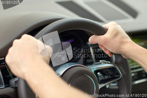 Image of close up of male hands driving car