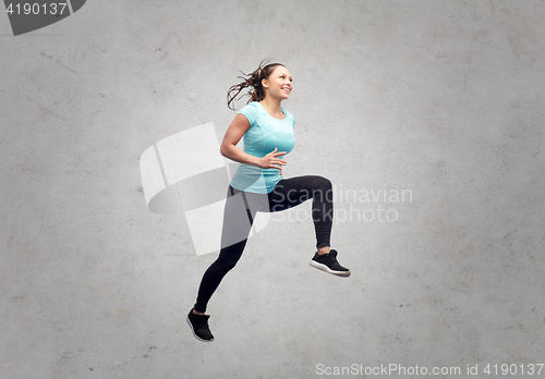 Image of happy smiling sporty young woman jumping in air