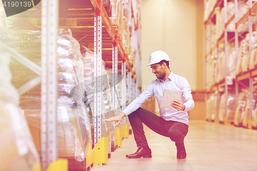 Image of happy businessman with tablet pc at warehouse