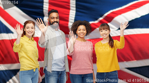 Image of international group of happy people waving hands