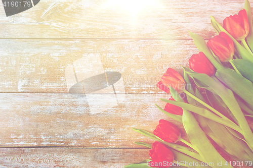 Image of close up of red tulips on wooden background