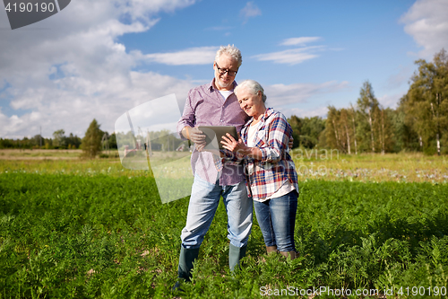 Image of happy senior couple with tablet pc at summer farm