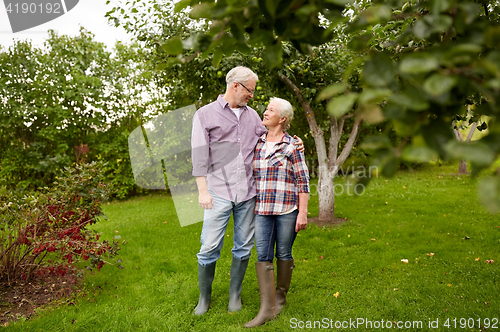 Image of happy senior couple hugging at summer garden