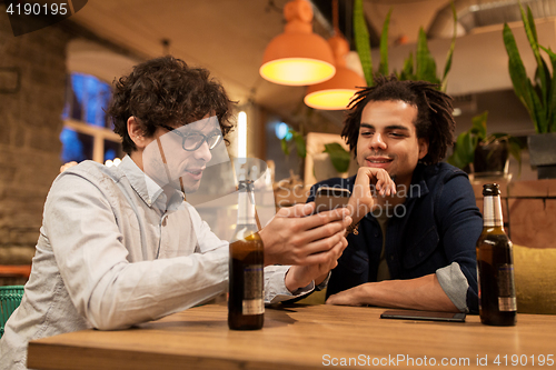 Image of men with smartphones drinking beer at bar or pub