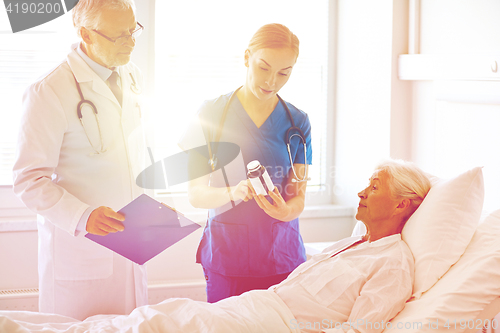 Image of doctor giving medicine to senior woman at hospital