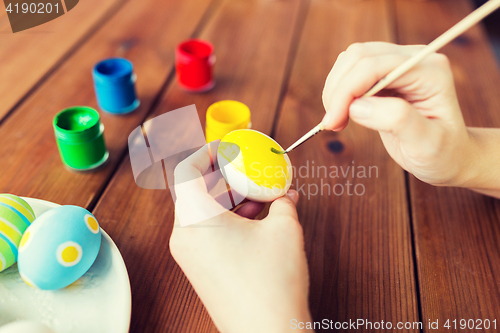 Image of close up of woman hands coloring easter eggs