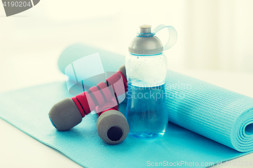 Image of close up of bottle, dumbbells and sports mat