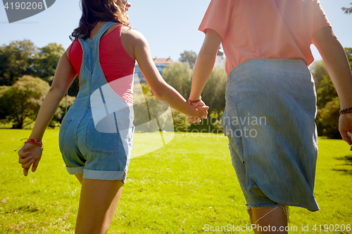 Image of happy teenage couple walking at summer park