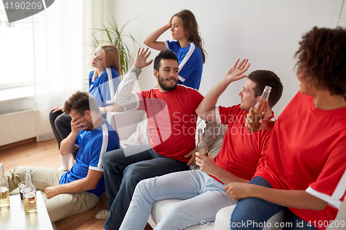 Image of friends or football fans watching soccer at home