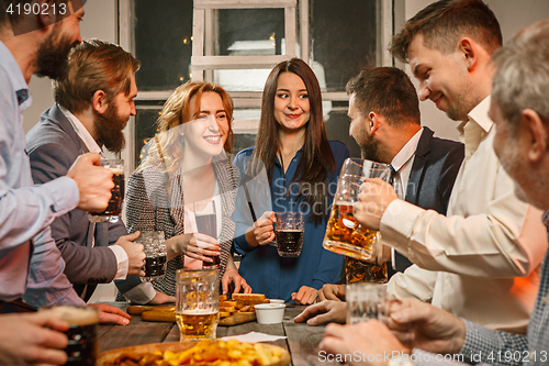 Image of Group of friends enjoying evening drinks with beer