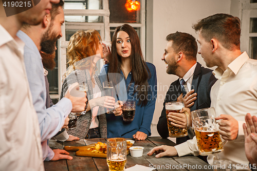 Image of Group of friends enjoying evening drinks with beer