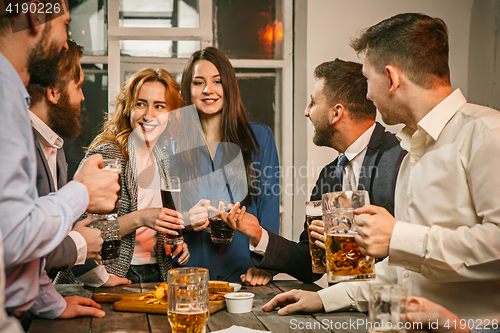 Image of Group of friends enjoying evening drinks with beer