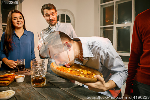 Image of Group of friends enjoying evening drinks with beer