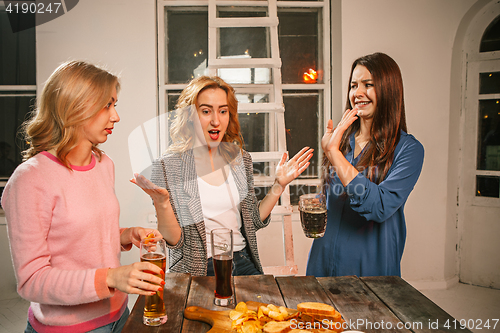 Image of Group of friends enjoying evening drinks with beer