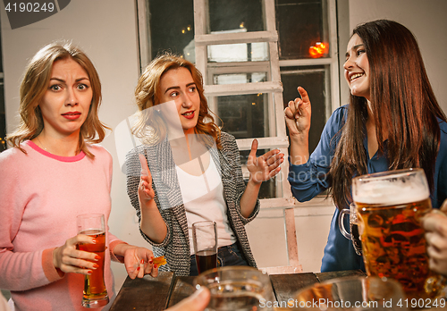 Image of Group of friends enjoying evening drinks with beer