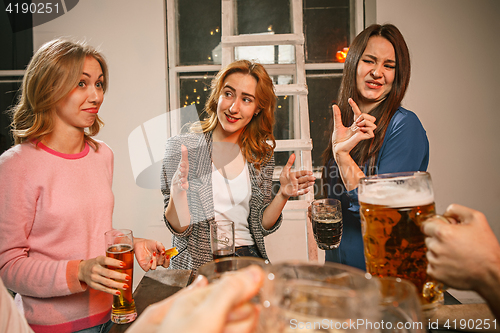 Image of Group of friends enjoying evening drinks with beer