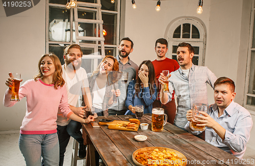 Image of Group of friends enjoying evening drinks with beer