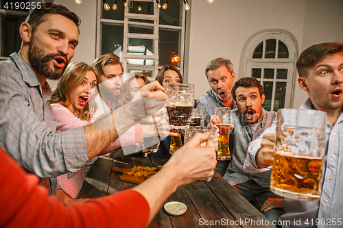 Image of Group of friends enjoying evening drinks with beer