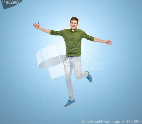 Image of smiling young man jumping in air