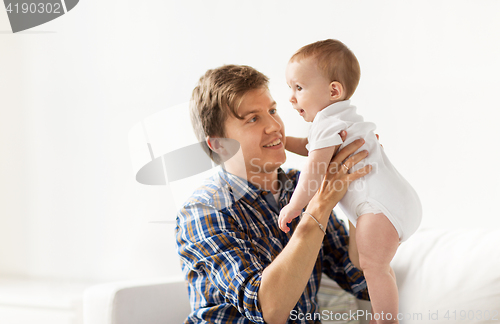 Image of happy young father with little baby at home