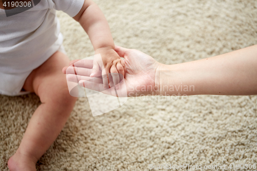 Image of close up of little baby and mother hands