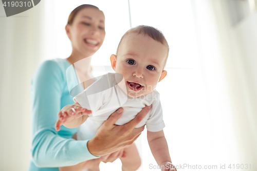 Image of happy young mother with little baby at home