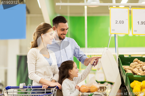 Image of family weighing oranges on scale at grocery store