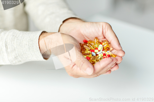 Image of close up of senior man hands holding pills