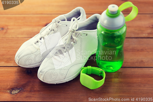 Image of close up of sneakers, bracelet and water bottle