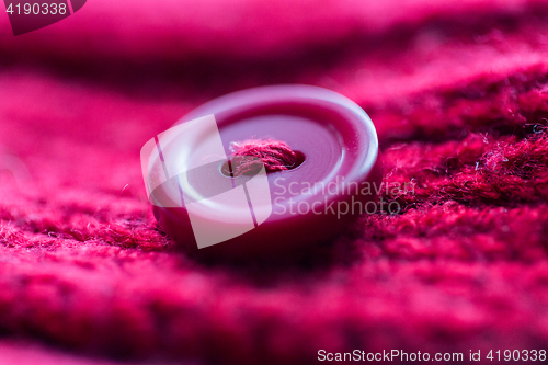 Image of close up of button sewn to knitted item
