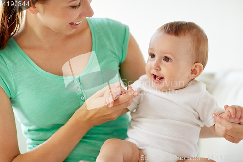 Image of happy young mother with little baby at home