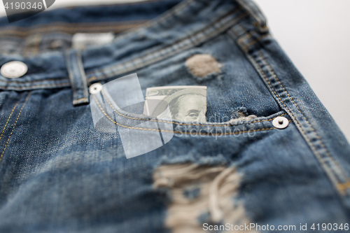 Image of dollar money in pocket of denim pants or jeans