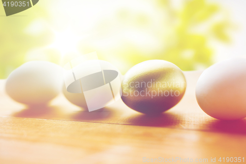 Image of close up of golden and white easter eggs on wood