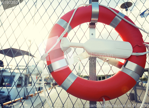 Image of lifebuoy over moored boats on pier