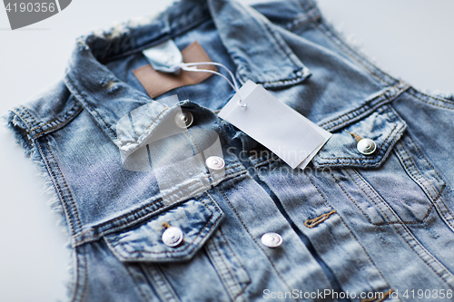 Image of close up of denim waistcoat with price tag